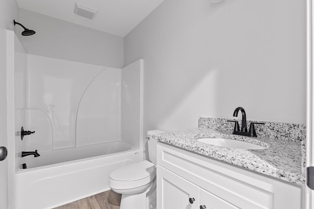 full bathroom featuring hardwood / wood-style flooring, vanity, shower / washtub combination, and toilet