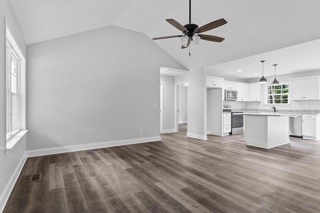 unfurnished living room with lofted ceiling, sink, dark hardwood / wood-style floors, and ceiling fan