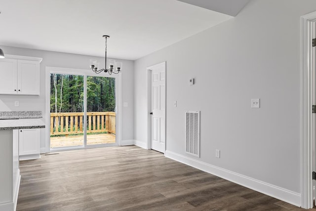 unfurnished dining area featuring dark hardwood / wood-style floors and a notable chandelier