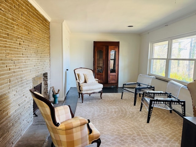 sitting room with a brick fireplace, ornamental molding, and brick wall