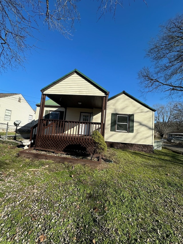 rear view of property with a wooden deck and a yard