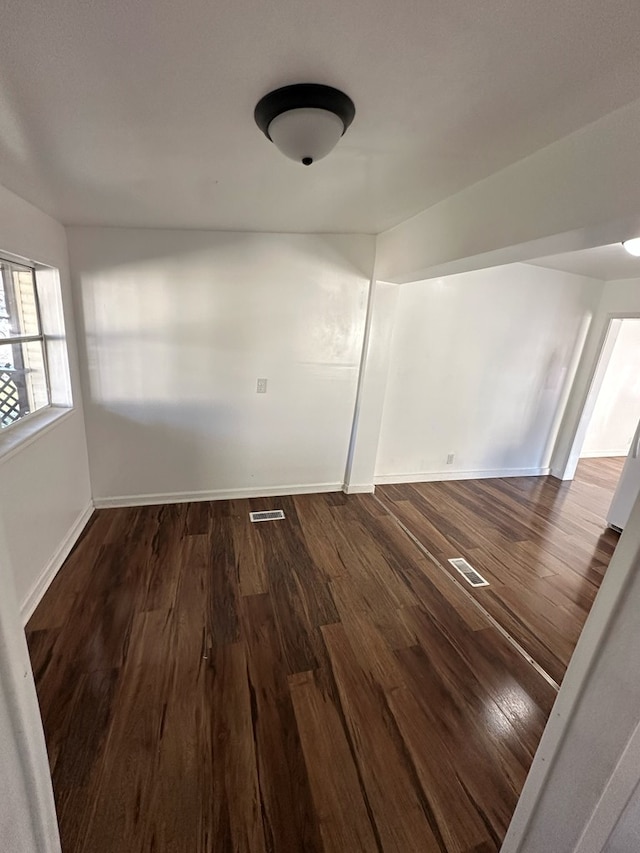 unfurnished room with dark hardwood / wood-style flooring