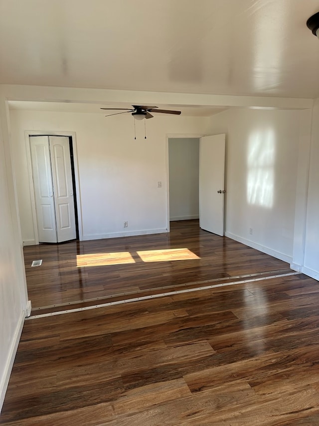 unfurnished room with dark wood-type flooring and ceiling fan