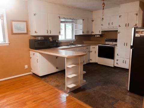 kitchen featuring white cabinetry, stainless steel fridge, kitchen peninsula, and electric range