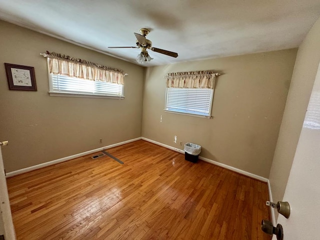 spare room featuring wood-type flooring and ceiling fan