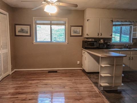 kitchen featuring wood-type flooring, a wealth of natural light, sink, and white cabinets