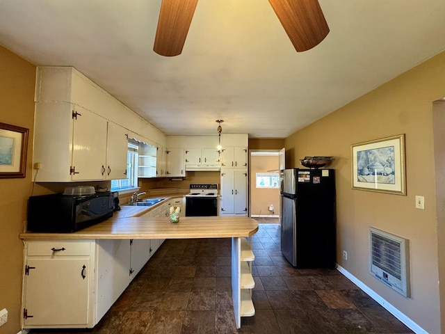 kitchen featuring stainless steel fridge, electric range, heating unit, white cabinets, and kitchen peninsula