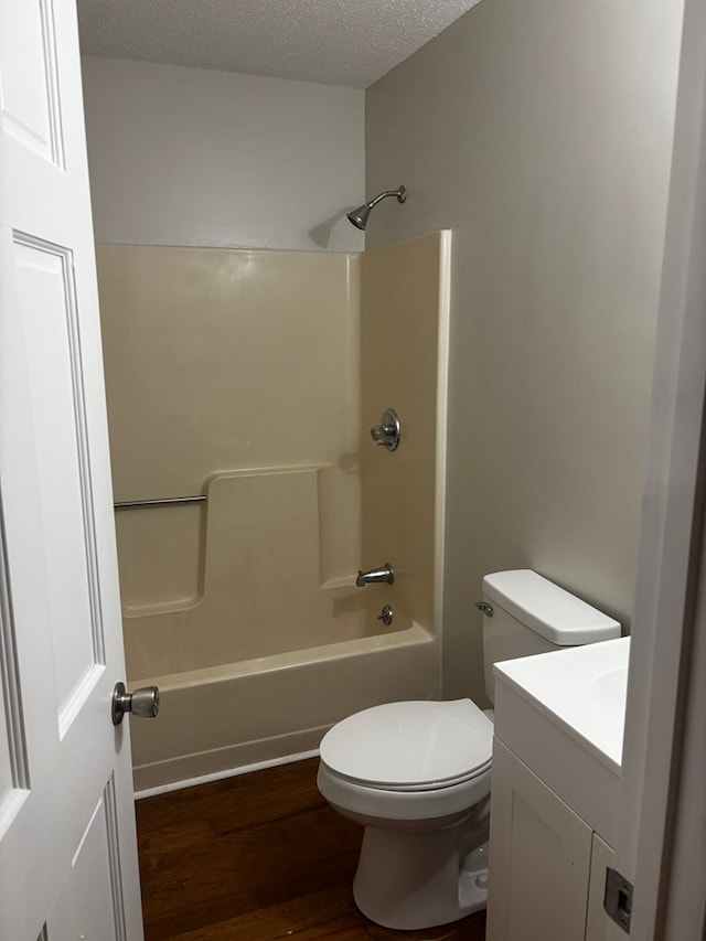 19 5th Ave, Eton, GA 30705 - bathroom featuring vanity, wood finished floors, shower / tub combination, toilet, and a textured ceiling
