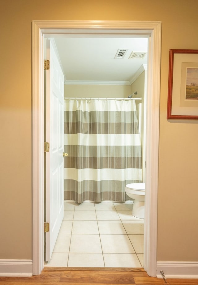 1730 Brighton Way, Dalton, GA 30720 - full bath featuring toilet, crown molding, tile patterned flooring, baseboards, and a shower with shower curtain