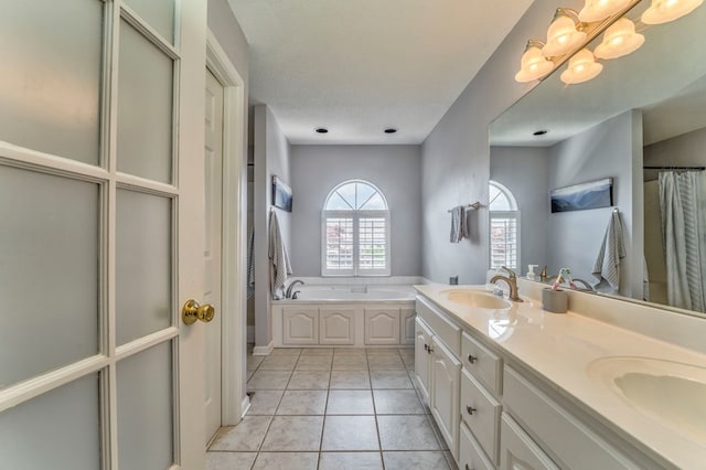 bathroom with a bath, tile patterned floors, double vanity, and a chandelier