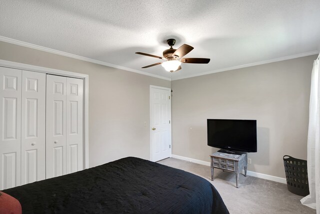 unfurnished bedroom featuring crown molding, ceiling fan, a textured ceiling, light carpet, and a closet