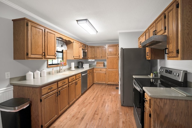 kitchen featuring sink, stainless steel appliances, ornamental molding, light hardwood / wood-style floors, and a textured ceiling