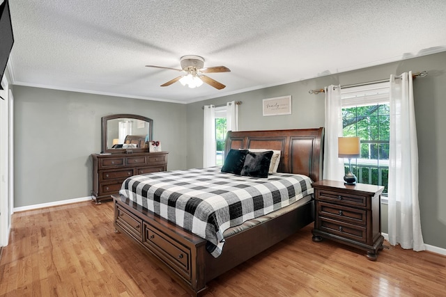 bedroom with multiple windows, crown molding, light hardwood / wood-style flooring, and ceiling fan