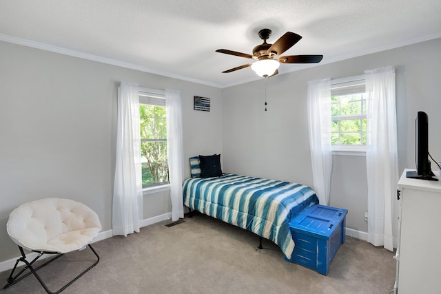 carpeted bedroom featuring ceiling fan, ornamental molding, and a textured ceiling