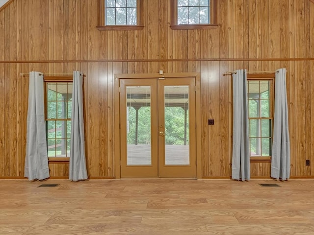 entryway with french doors, wood finished floors, and wood walls