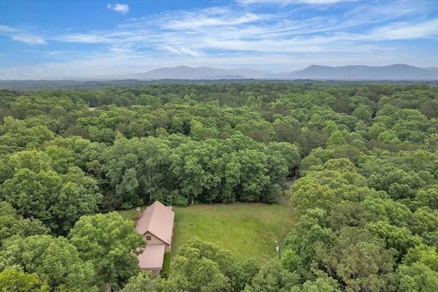 aerial view of a heavily wooded area and a mountainous background