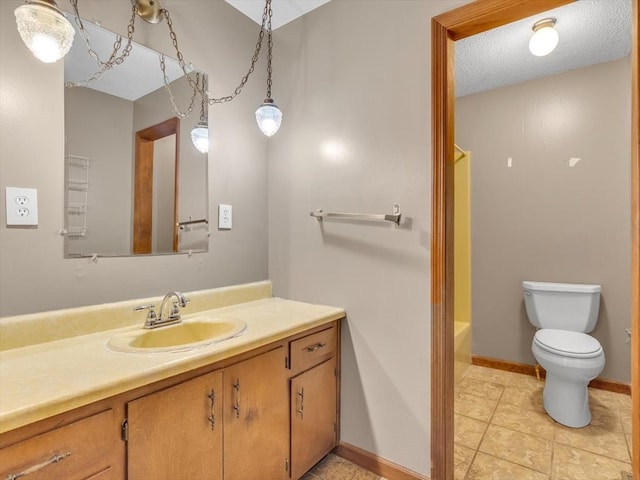 bathroom with toilet, vanity, baseboards, and tile patterned flooring