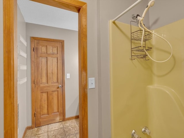 hallway with baseboards and light stone finish floors