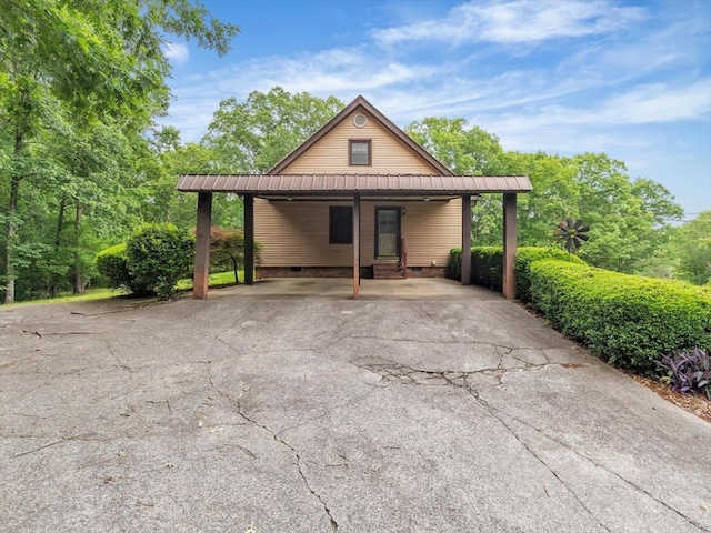 view of front facade featuring metal roof, a carport, crawl space, and driveway