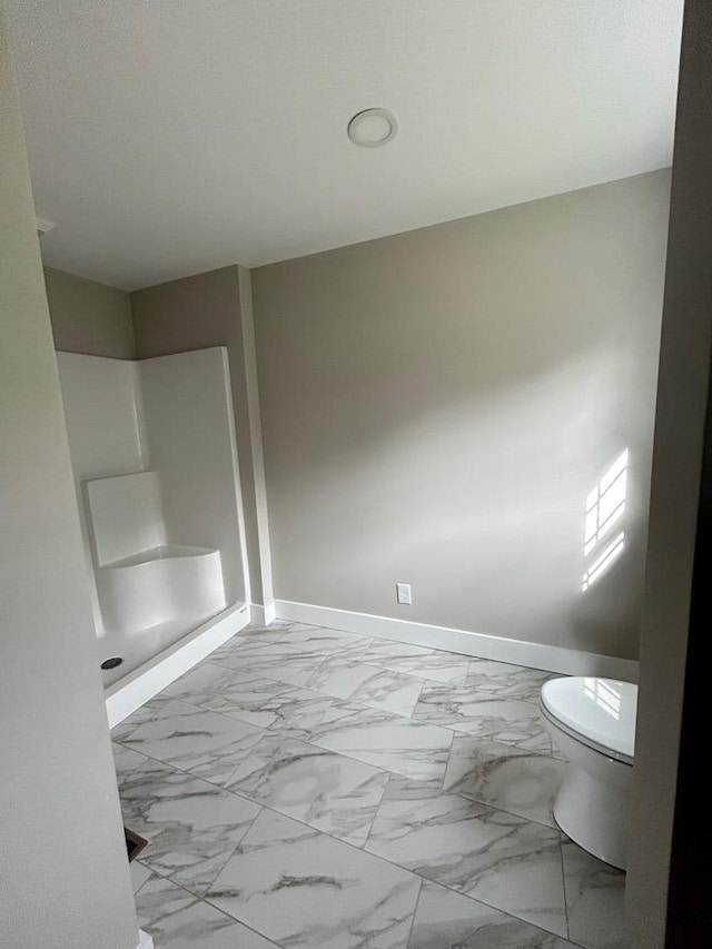 bathroom featuring walk in shower and toilet