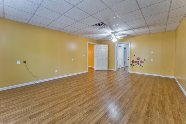 spare room featuring a drop ceiling, ceiling fan, and light wood-type flooring