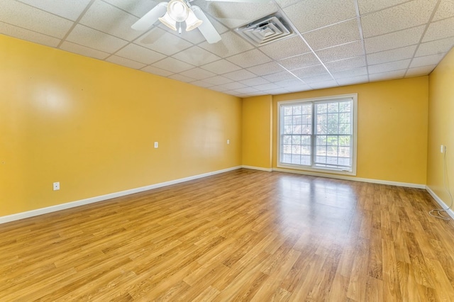 spare room with a paneled ceiling, ceiling fan, and light wood-type flooring