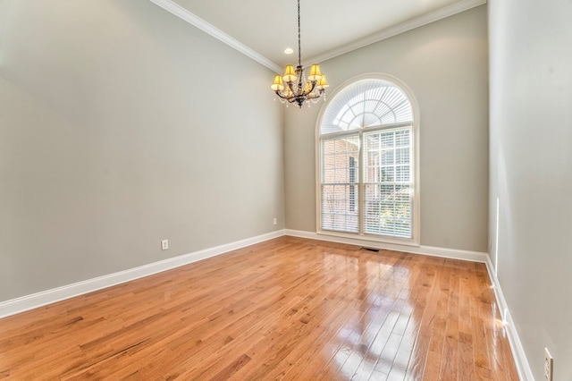 unfurnished room with hardwood / wood-style flooring, ornamental molding, and a chandelier