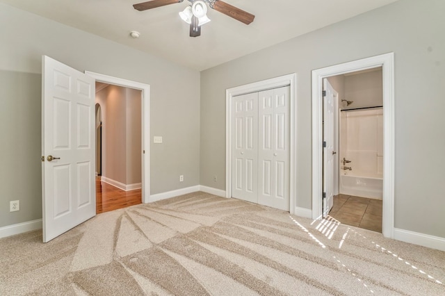 unfurnished bedroom featuring carpet floors, connected bathroom, ceiling fan, and a closet