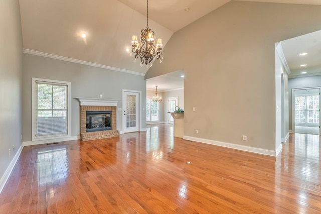 unfurnished living room with a healthy amount of sunlight, a fireplace, and an inviting chandelier