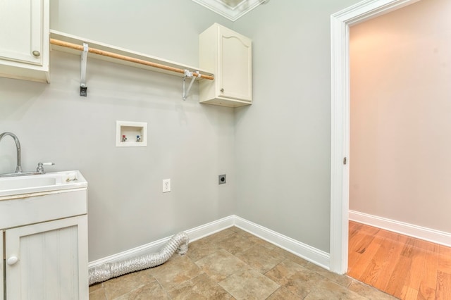 clothes washing area with electric dryer hookup, sink, washer hookup, and cabinets