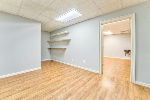 unfurnished room featuring a paneled ceiling and light wood-type flooring