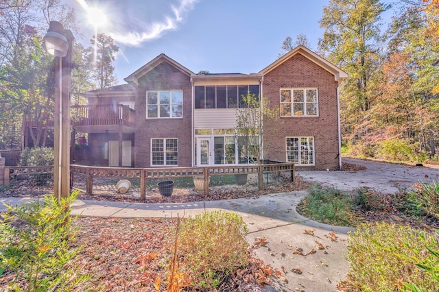 back of house with a sunroom and a balcony