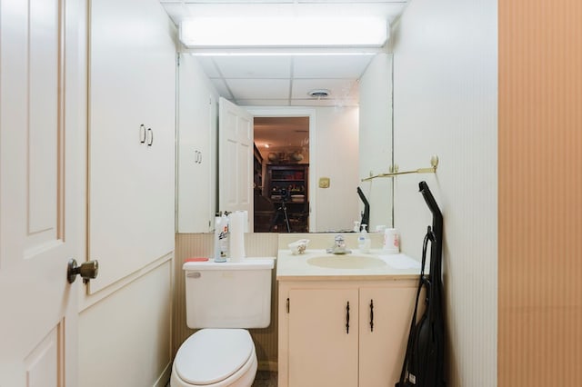 bathroom with vanity, a paneled ceiling, and toilet