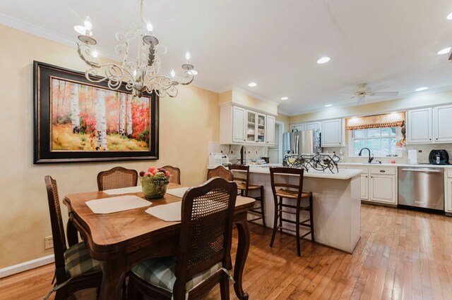 dining area with ornamental molding, sink, ceiling fan, and light wood-type flooring