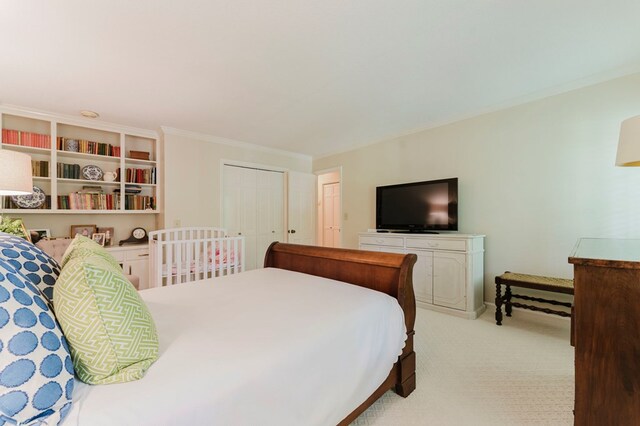 bedroom featuring crown molding, a closet, and light carpet