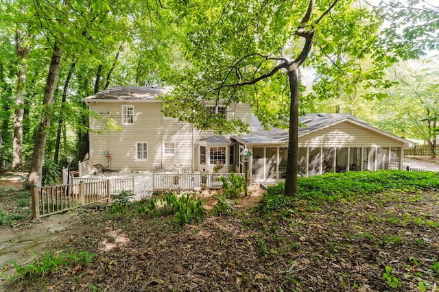 back of house featuring a wooden deck and a sunroom