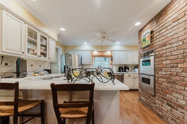 kitchen with white cabinetry, kitchen peninsula, a kitchen breakfast bar, and stainless steel fridge with ice dispenser