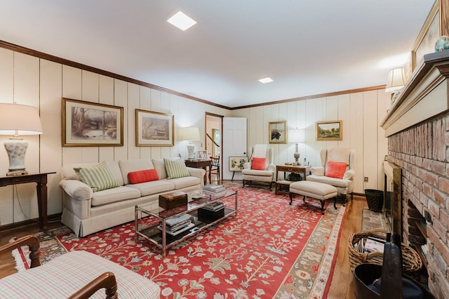 living room with crown molding, hardwood / wood-style floors, and a brick fireplace