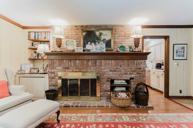 living room with crown molding, a fireplace, and light hardwood / wood-style floors