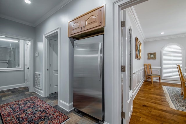 interior space featuring dark wood-type flooring, stainless steel fridge, ornamental molding, and light brown cabinets