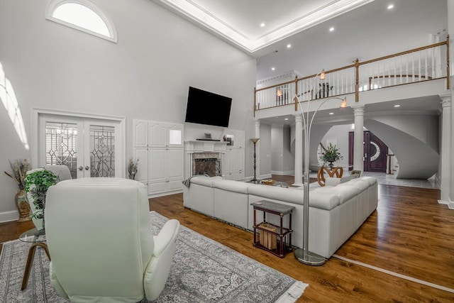 living room featuring crown molding, hardwood / wood-style floors, decorative columns, and french doors