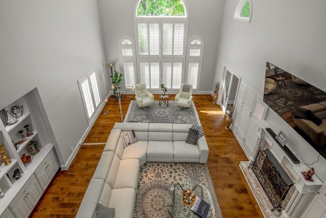 living room featuring dark wood-type flooring and a towering ceiling