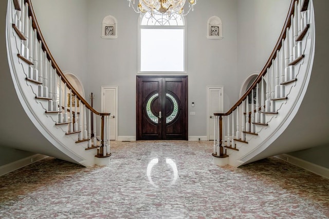 entrance foyer with a towering ceiling and a notable chandelier