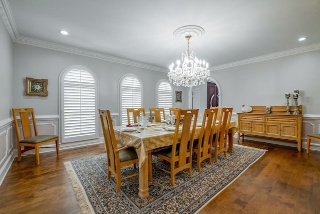 dining room with crown molding, dark wood-type flooring, and a chandelier