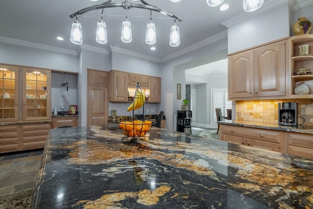 kitchen with dark stone countertops, hanging light fixtures, and crown molding