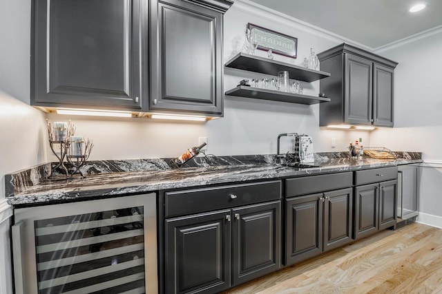 kitchen with sink, beverage cooler, dark stone counters, light hardwood / wood-style floors, and crown molding