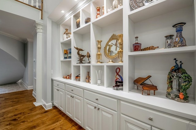 interior space featuring light hardwood / wood-style floors, built in features, and ornate columns