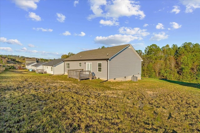 rear view of property featuring a yard, a deck, and central air condition unit