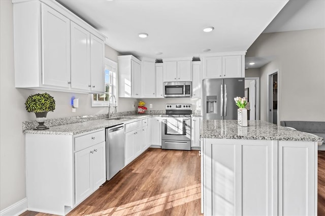 kitchen featuring light stone counters, sink, stainless steel appliances, and white cabinets