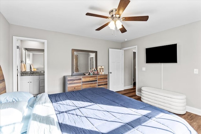 bedroom with connected bathroom, dark wood-type flooring, and ceiling fan